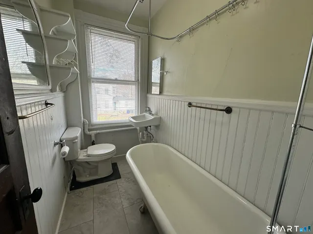 a bathroom with a sink a toilet a tub and window
