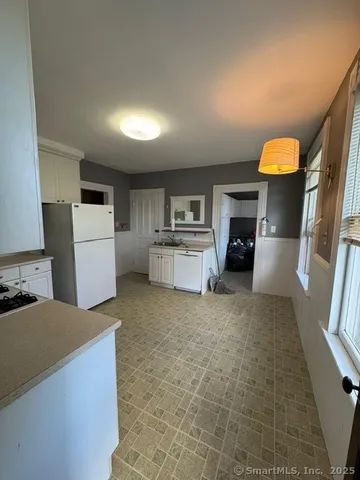 a kitchen with a refrigerator and a stove top oven
