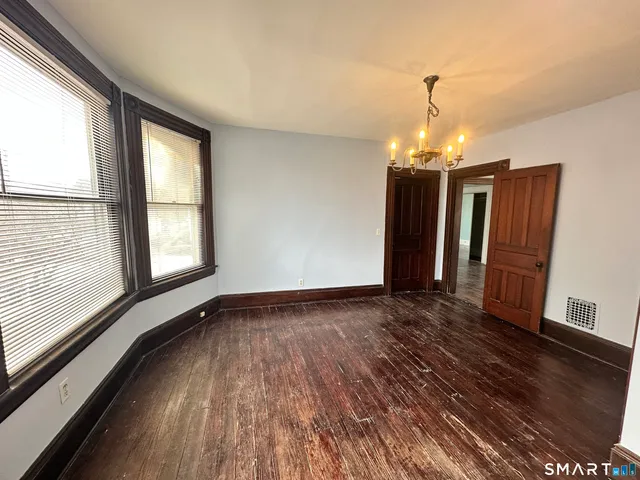a view of a livingroom with wooden floor and chandelier