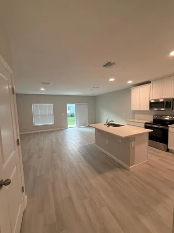 a kitchen with stainless steel appliances granite countertop a stove a sink and a refrigerator