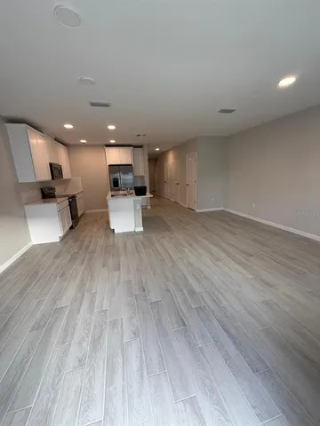 a view of a living room and kitchen with wooden floor