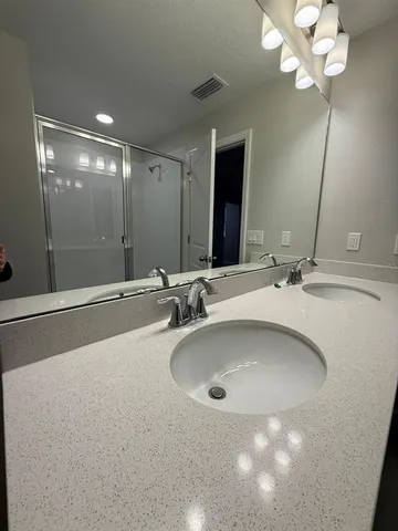 a bathroom with a double vanity sink and a mirror