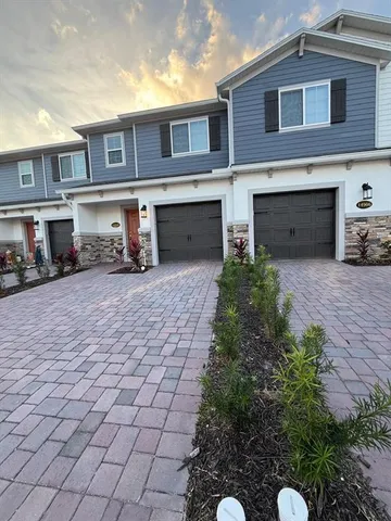 a front view of a house with yard and trees in the background