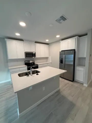 a kitchen with stainless steel appliances a refrigerator sink and microwave