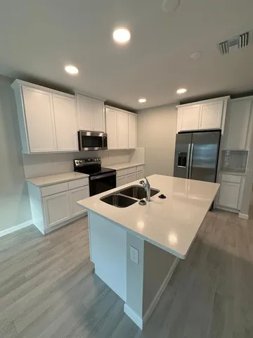 a kitchen with kitchen island a stove a sink and a refrigerator
