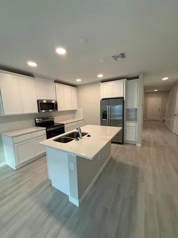 a kitchen with a sink a stove a refrigerator and a oven