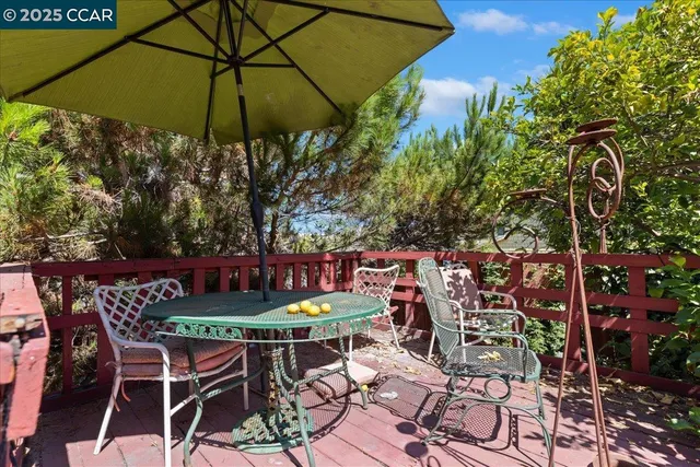 a outdoor view with a table and chairs under an umbrella