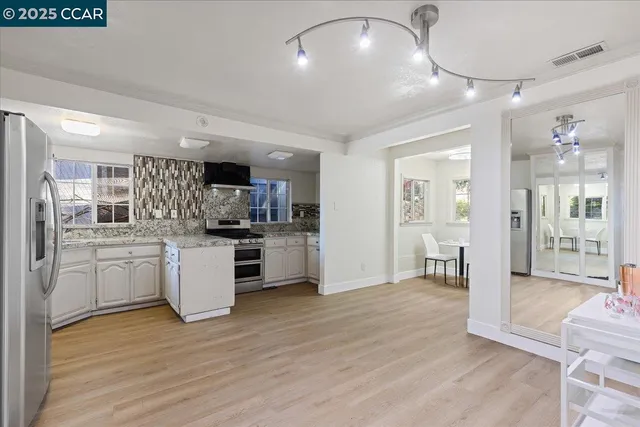 a view of kitchen with sink and refrigerator