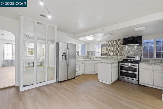 a kitchen with white cabinets and stainless steel appliances