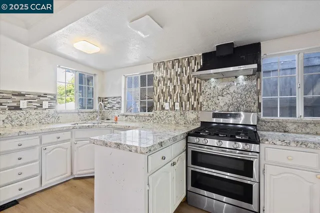 a kitchen with white cabinets and appliances