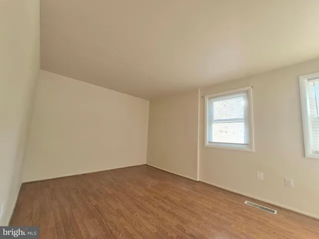 an empty room with a wooden door and a window
