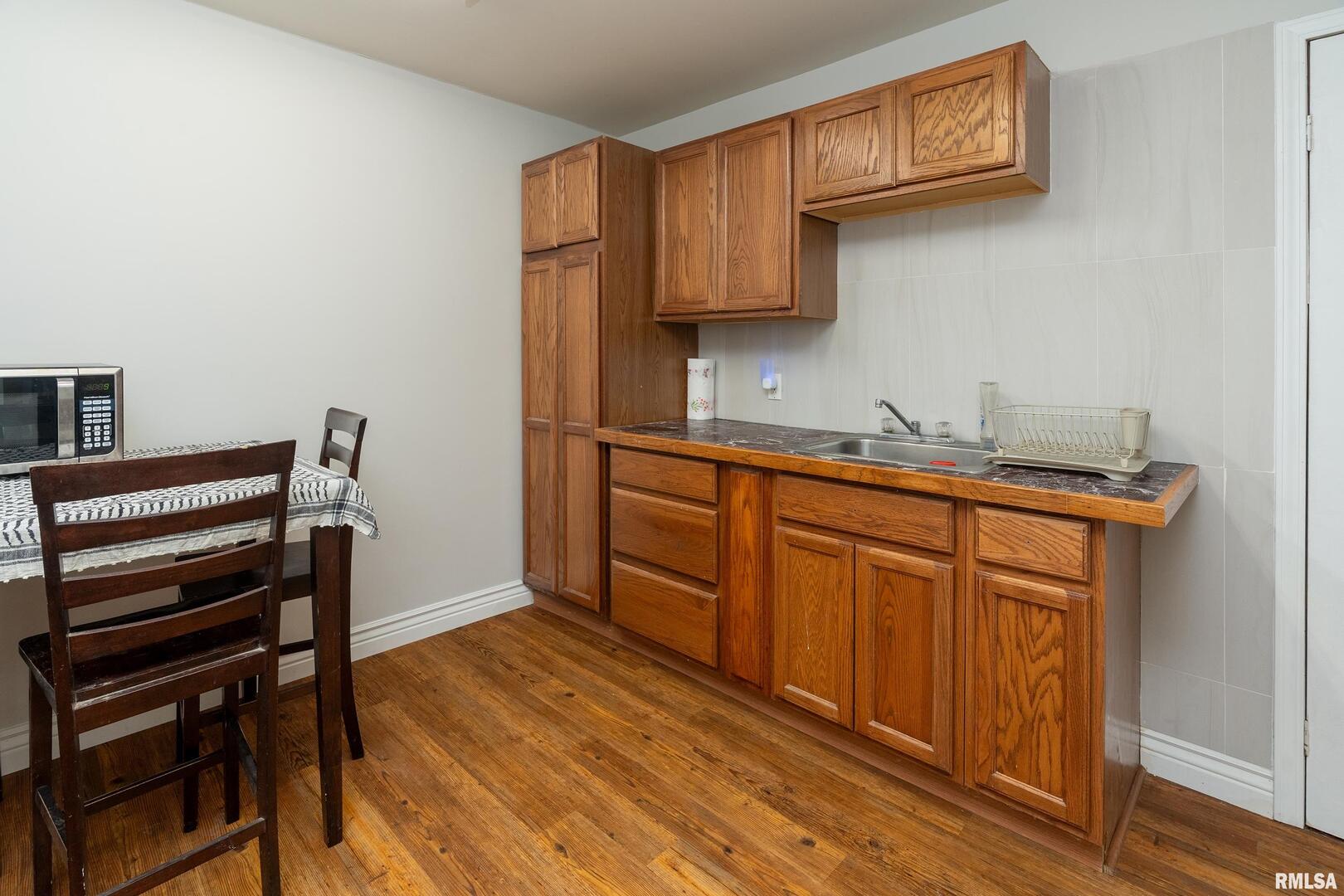 10543 Highway 149 Murphysboro, IL 62966 - Photo 24 of 54 a kitchen with stainless steel appliances granite countertop a sink cabinets and wooden floor