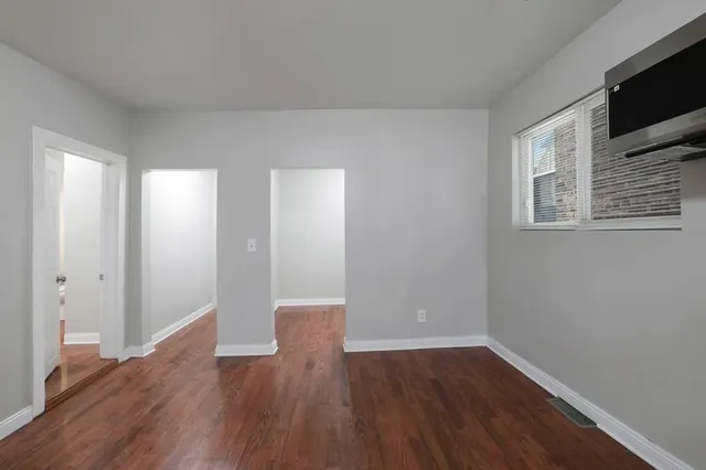 a view of a room with wooden floor and tv
