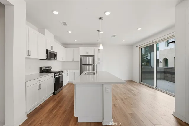 a kitchen with stainless steel appliances kitchen island granite countertop a stove and a refrigerator