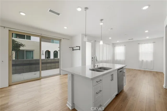 a kitchen with stainless steel appliances granite countertop a sink a counter space and wooden floor
