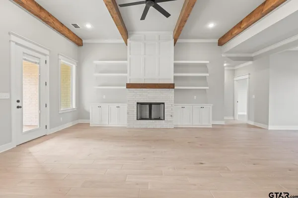 a view of empty room with wooden floor and fireplace