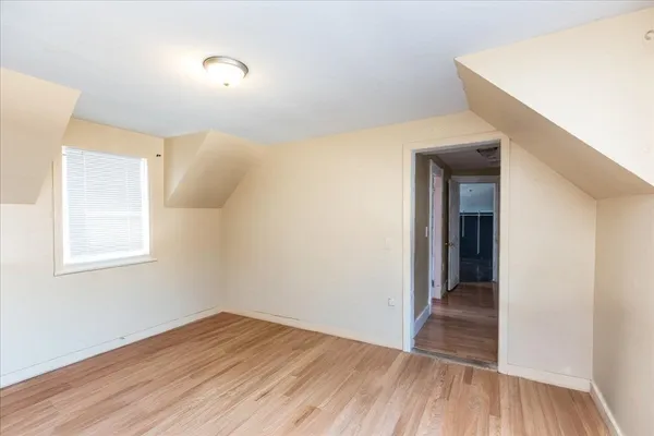 a view of a hallway with wooden floor and a window