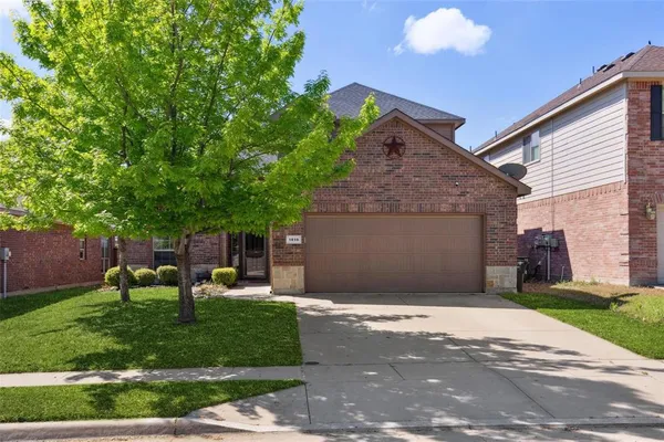 a front view of a house with a garden and trees