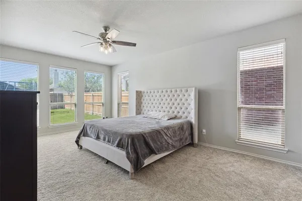 a spacious bedroom with a bed and glass door