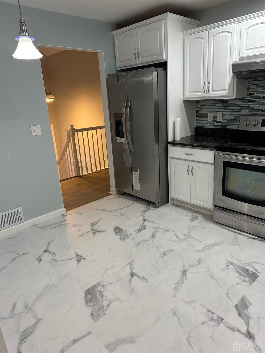 103 Spook Ridge Road Montague, NJ 07827 - Photo 17 of 54 a kitchen with granite countertop a refrigerator a stove a microwave and cabinets