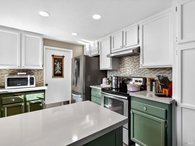 a kitchen with granite countertop a stove sink and cabinets