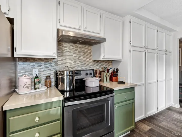 a kitchen with granite countertop cabinets stainless steel appliances and a wooden floor