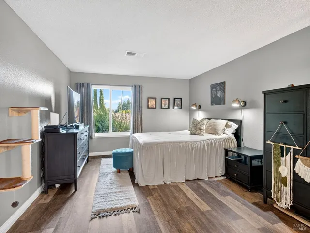 a bed room with a bed furniture tv and a window