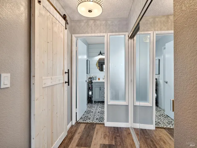 a view of a hallway with wooden floor and bathroom
