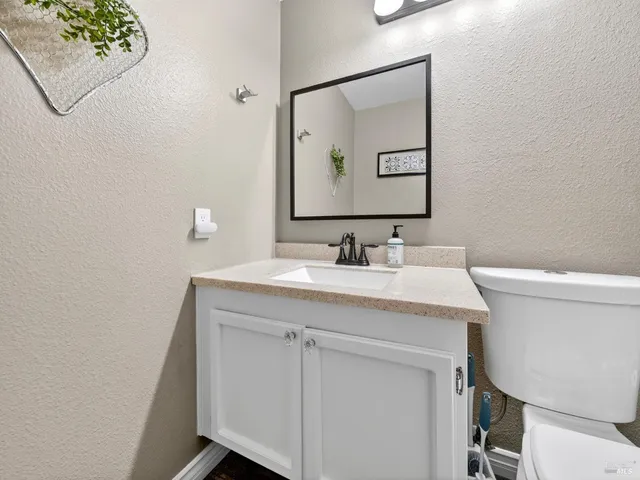 a bathroom with a sink vanity and a toilet