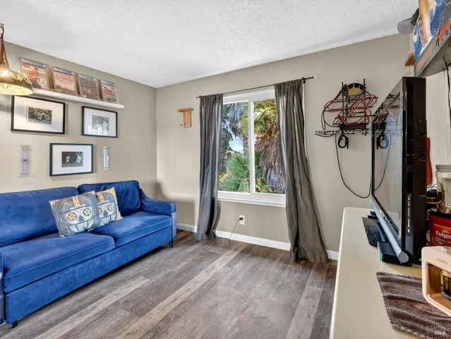 a living room with furniture a flat screen tv and a window