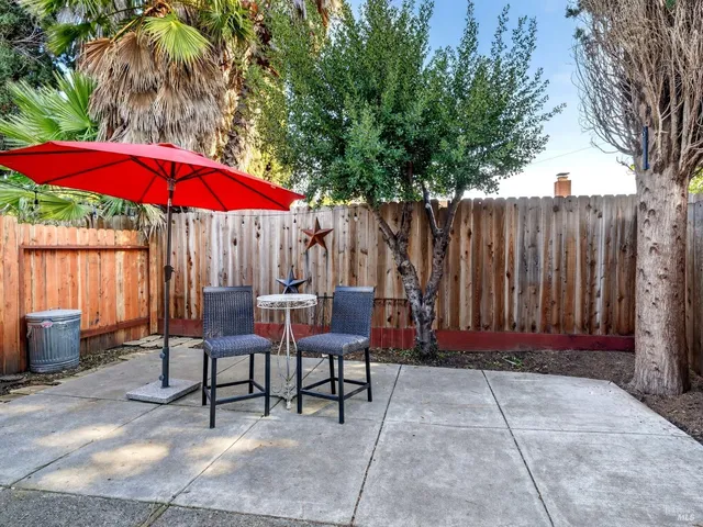 a view of a backyard with a patio and wooden fence