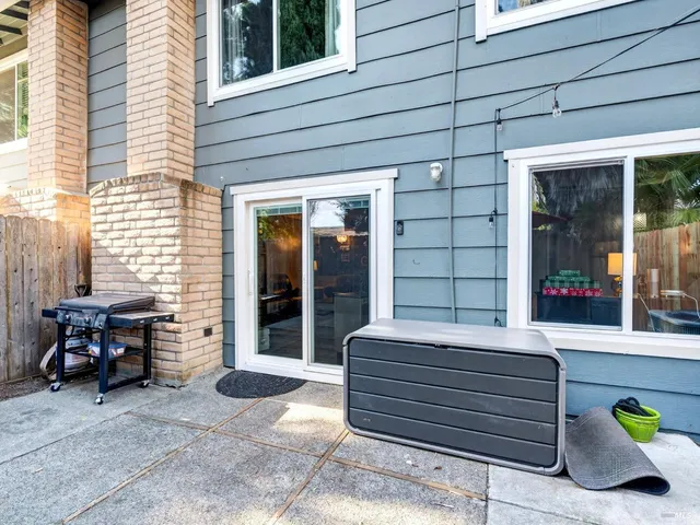 a patio with a table and chairs under an umbrella