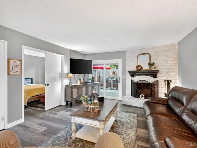 a living room with furniture a fireplace and a flat screen tv