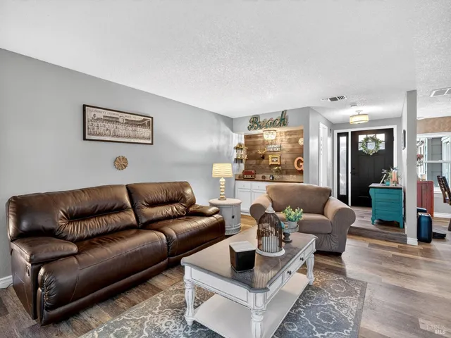 a living room with furniture and a wooden floor
