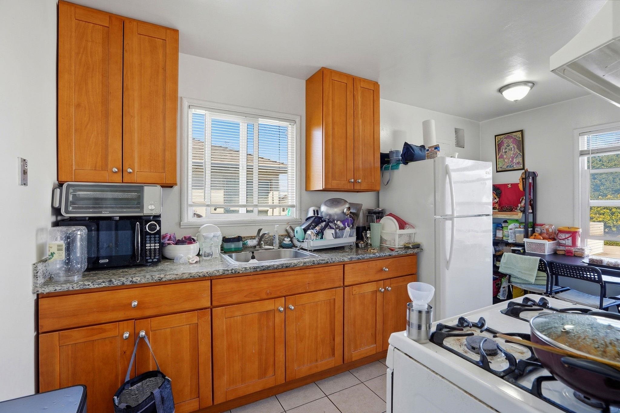 3224 Sacramento Street Berkeley, CA 94702 - Photo 11 of 21 a kitchen with stainless steel appliances granite countertop a sink stove and refrigerator