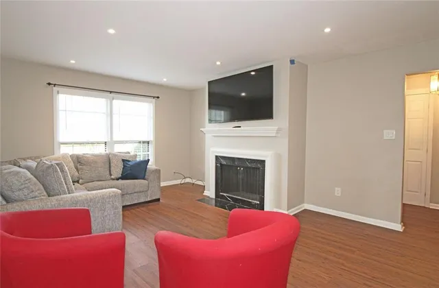 a living room with furniture a flat screen tv and a fireplace