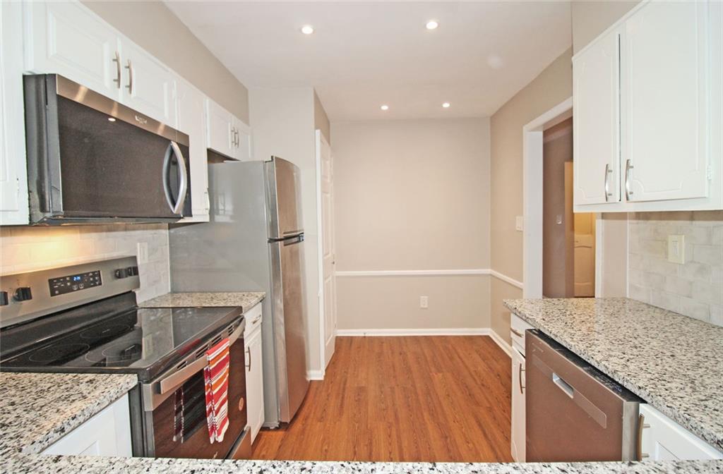 38 La Rue Place Northwest Atlanta, GA 30327 - Photo 11 of 78 a kitchen with stainless steel appliances granite countertop a refrigerator and a stove top oven