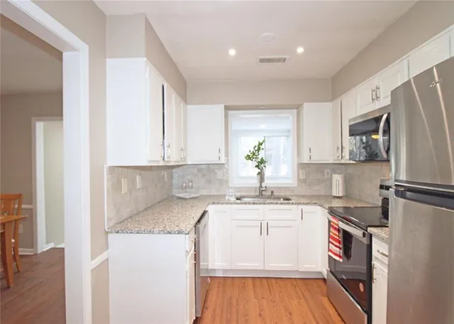 a kitchen with stainless steel appliances granite countertop a sink stove and microwave