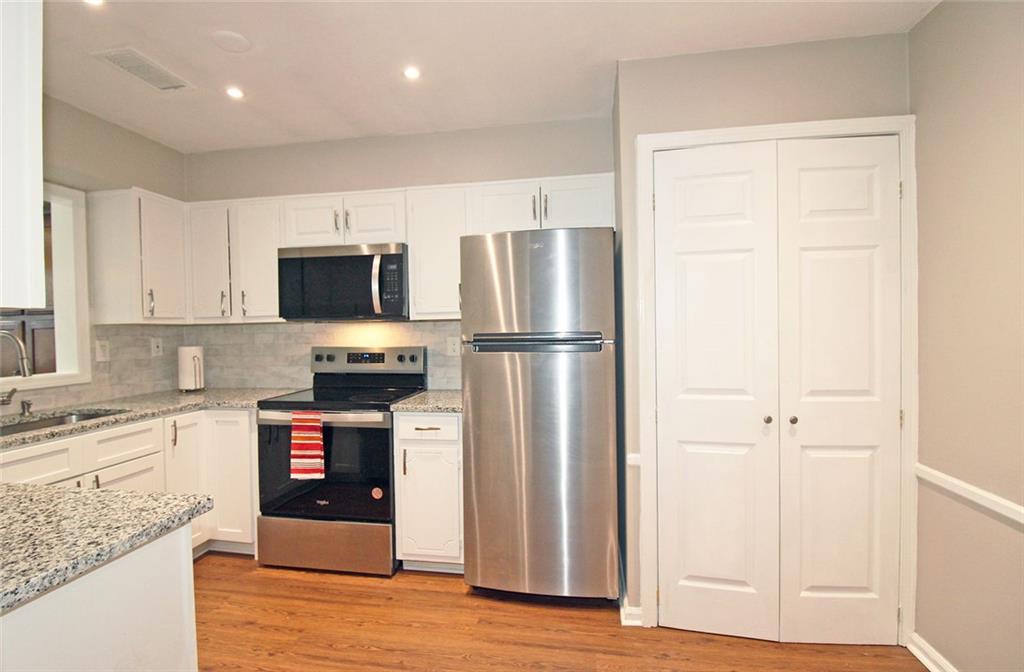 38 La Rue Place Northwest Atlanta, GA 30327 - Photo 9 of 78 a kitchen with a refrigerator and a stove top oven