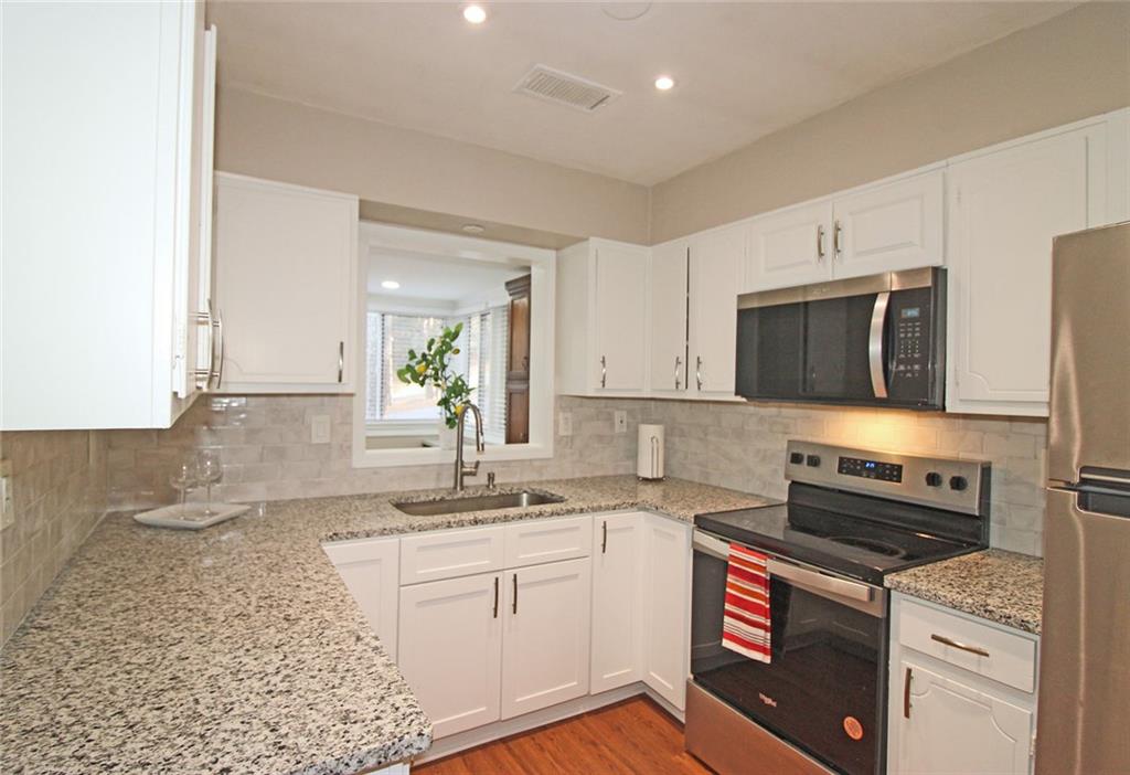 38 La Rue Place Northwest Atlanta, GA 30327 - Photo 10 of 78 a kitchen with stainless steel appliances granite countertop a sink stove and microwave