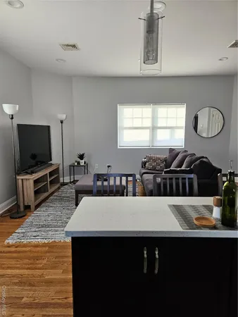 a living room with furniture a flat screen tv and a window