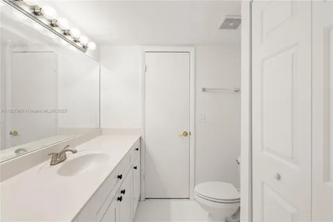 a bathroom with a double vanity sink toilet mirror and shower