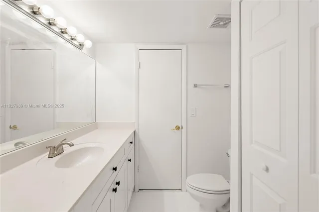 a bathroom with a double vanity sink toilet mirror and shower