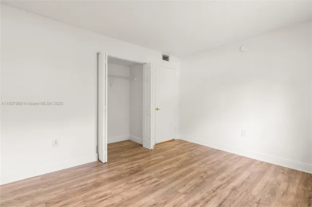 a view of a room with wooden floor
