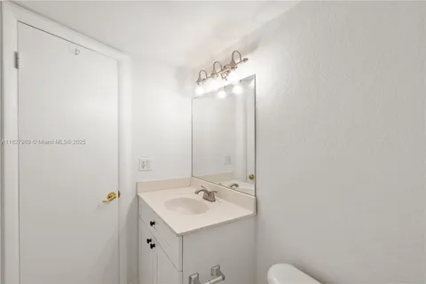 a bathroom with a sink and mirror with toilet