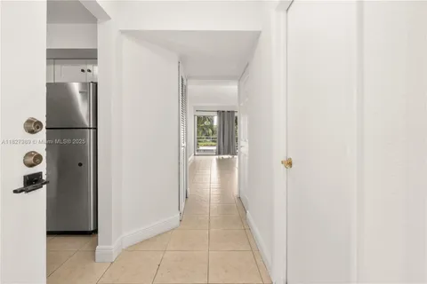 a view of a hallway with a white cabinet and a hallway