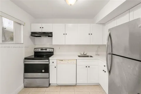 a kitchen with cabinets and white stainless steel appliances