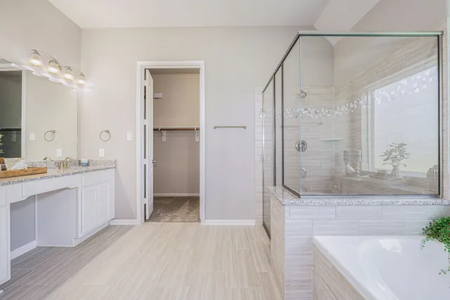 a bathroom with a granite countertop bathtub shower sink and mirror