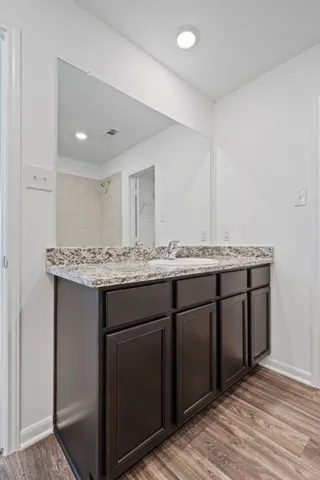 a bathroom with a granite countertop sink and a mirror