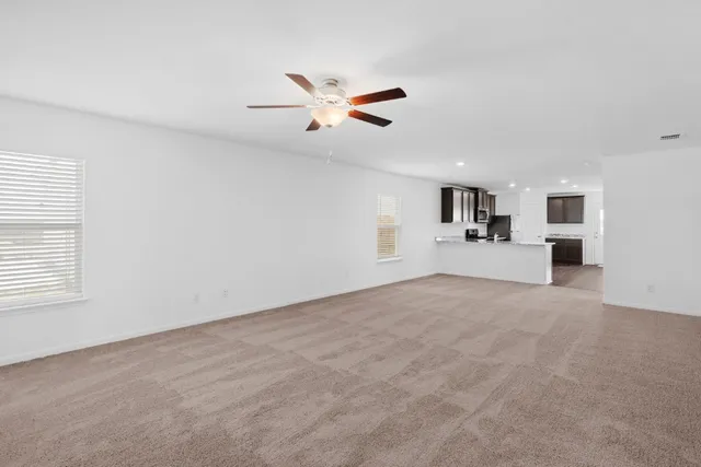 a view of a livingroom with a ceiling fan and window